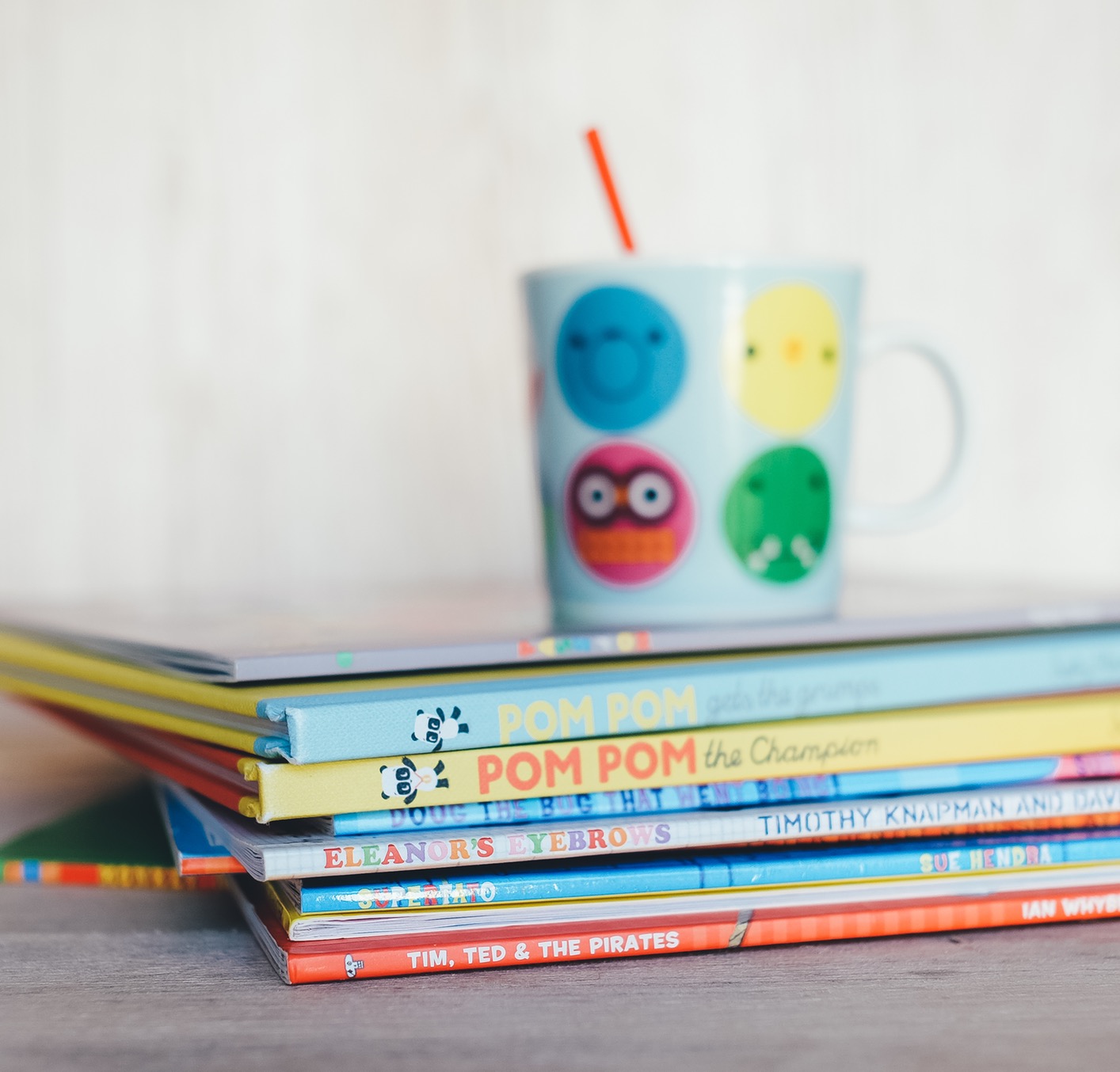 cup with a straw sitting on a stack of books